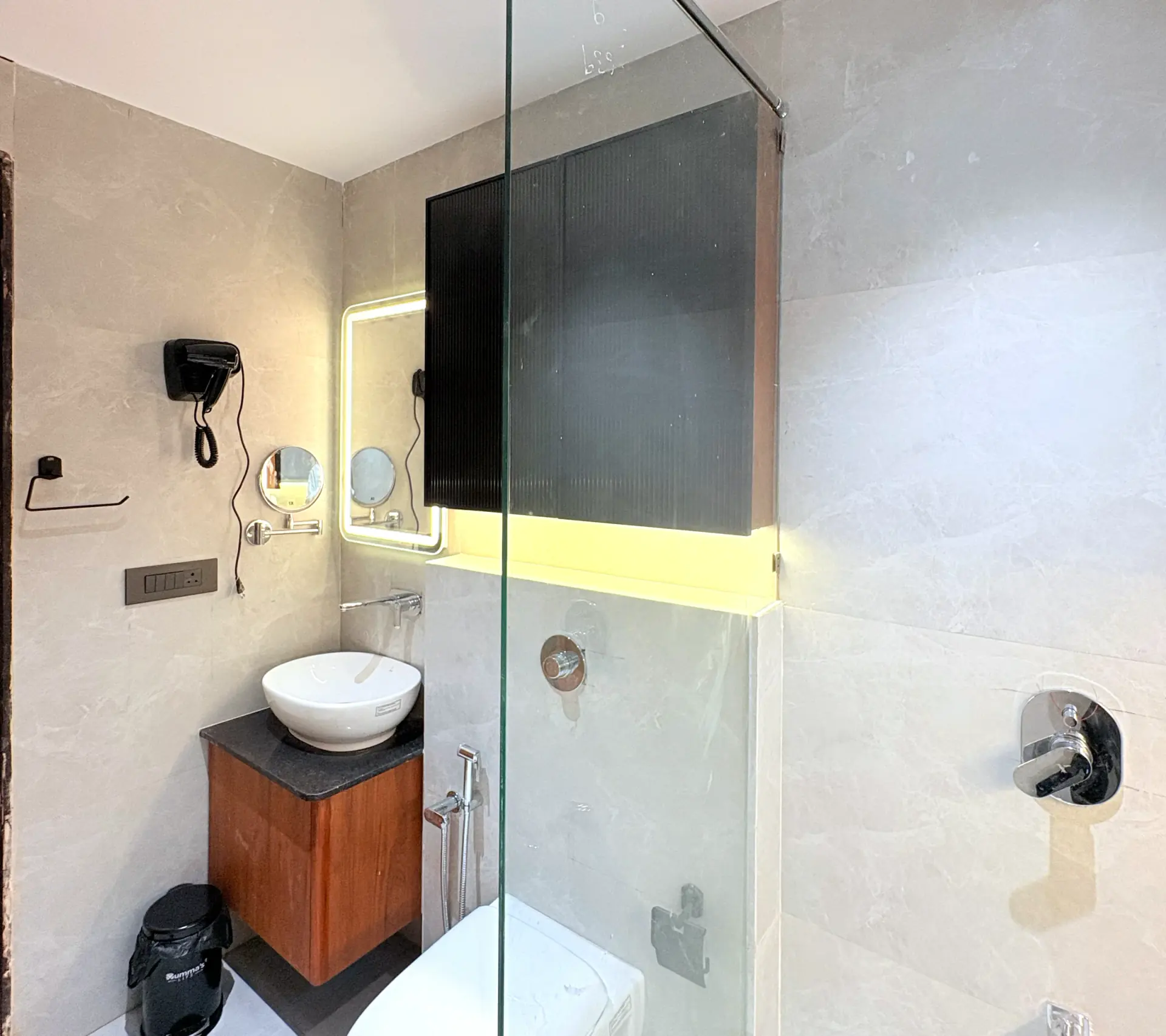 Bathroom vanity with a backlit mirror and stone counter