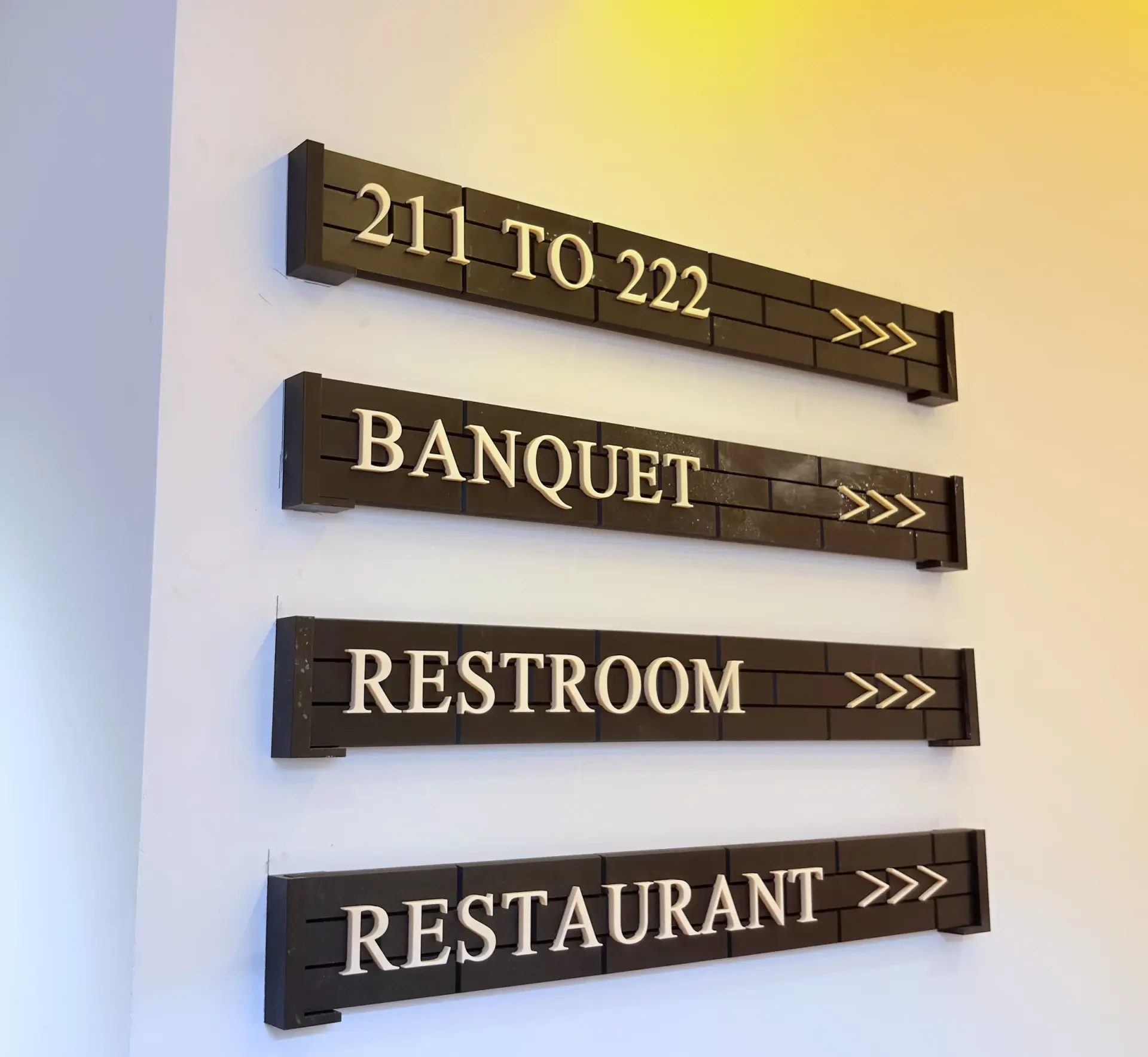 Timber and brass wayfinding signs for the banquet hall, restroom and restaurant